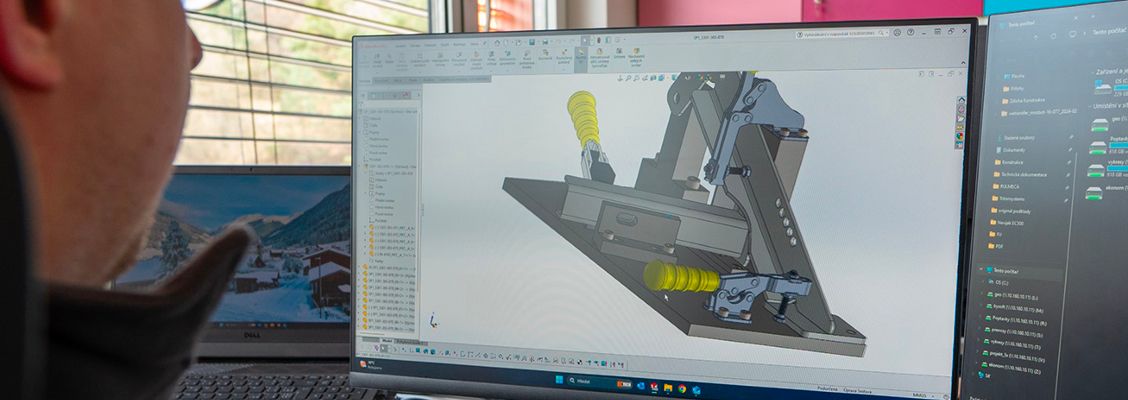 Engineer viewing a detailed 3D CAD model of a mechanical component on a monitor.